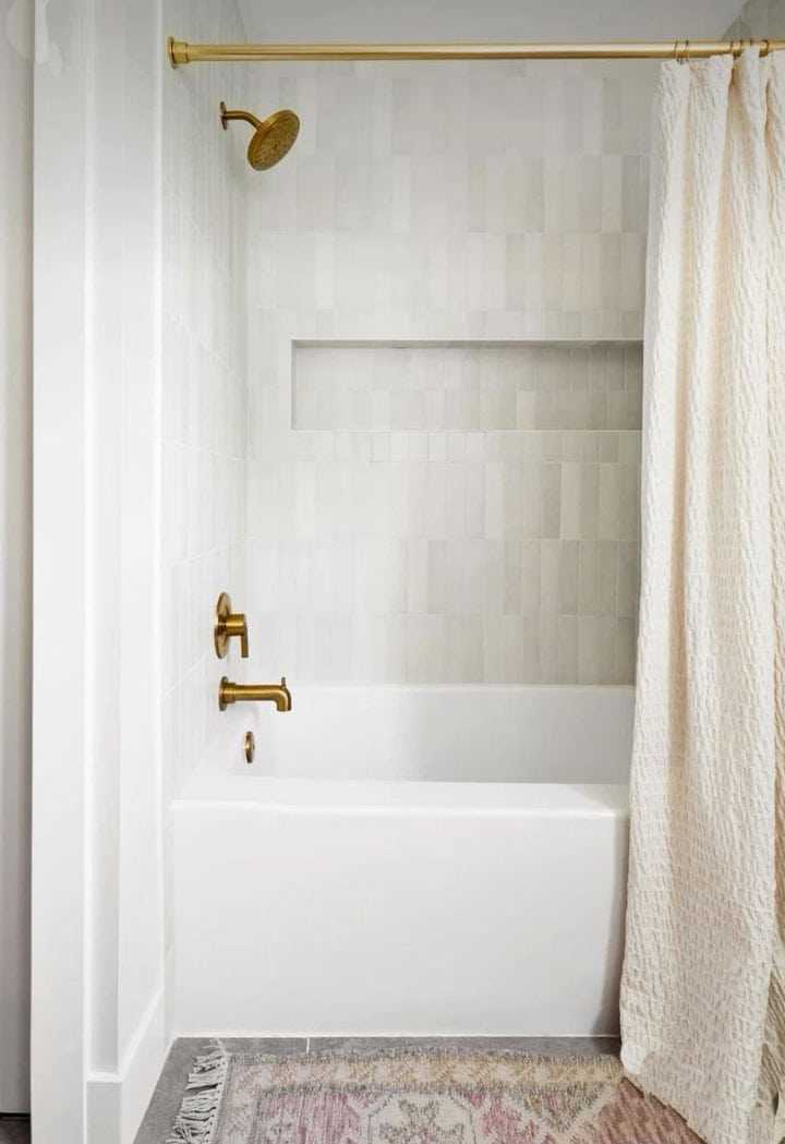 neutral-tile-in-bathtub-shower-combo-with-brass-fixtures neutral-tile-in-bathtub-shower-combo-with-brass-fixtures